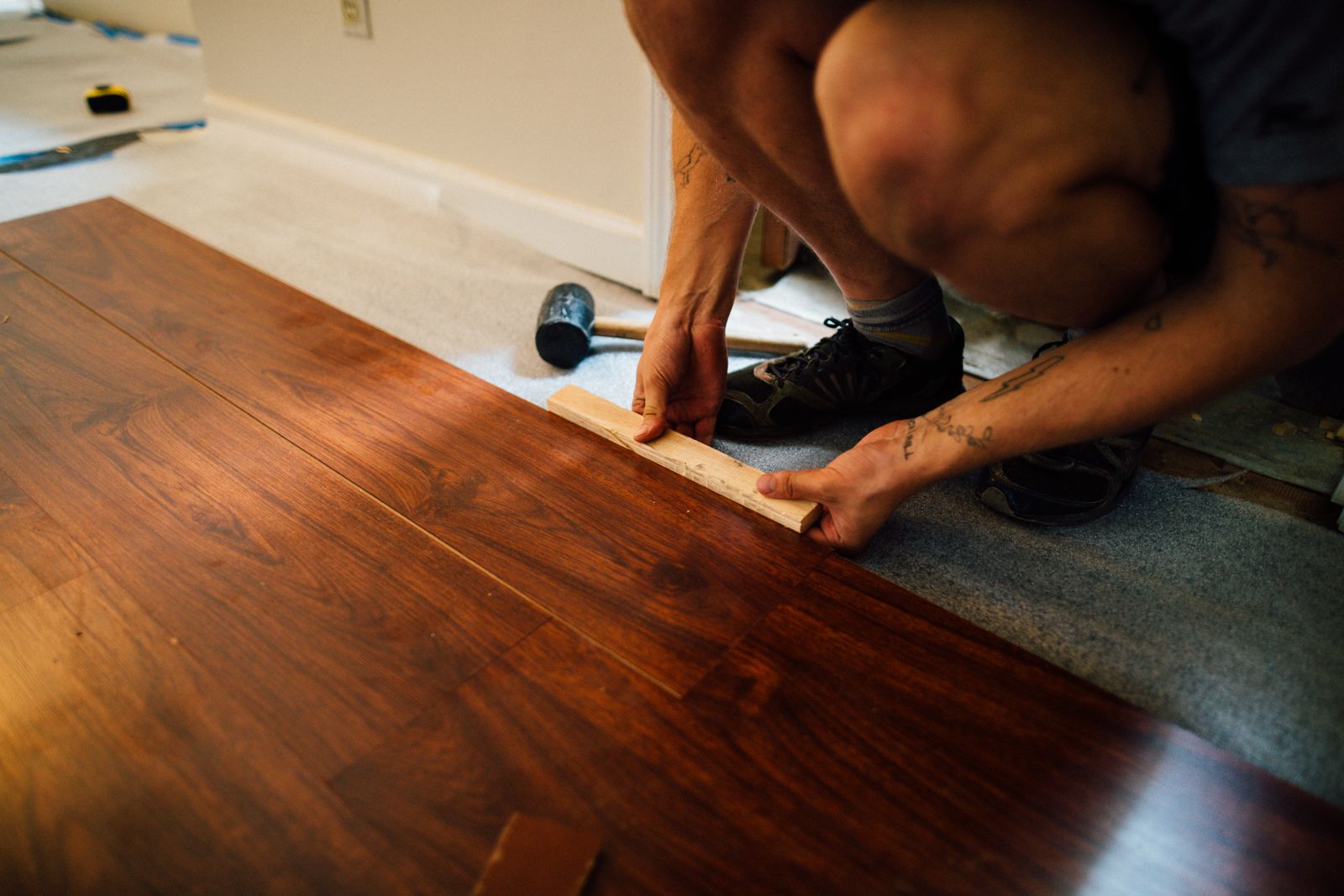Profissional instalando tábuas de piso em uma residência; fotografia ilustrativa